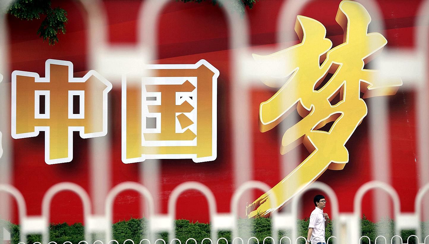 An advertisement board, seen through the fences, displays Chinese characters, which read "China Dream", in central Shanghai, on July 1, 2013. The characters are part of a slogan which read, "Come together and build the China Dream". -- PHOTO: REUTERS