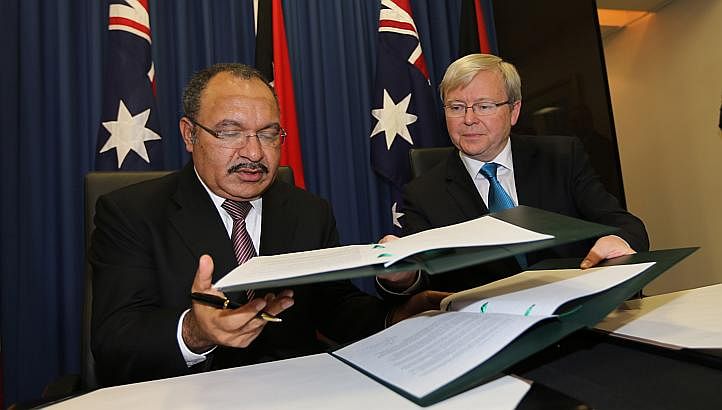Australian Prime Minister Kevin Rudd, (R) and Papua New Guinea's Prime Minister Peter O'Neill (L) exchange documents after signing an agreement during an announcement of a policy on asylum seekers in Brisbane on July 19, 2013. -- PHOTO: AFP