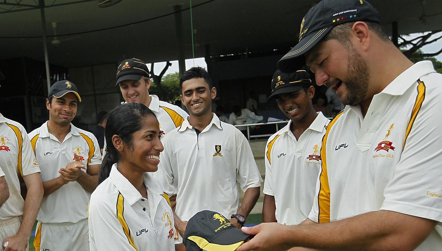 Diviya G.K., who received the club cap from Singapore Cricket Club captain Richard Stapley-Oh, should play abroad to further hone her skills, say pundits. -- ST PHOTO: MARK CHEONG