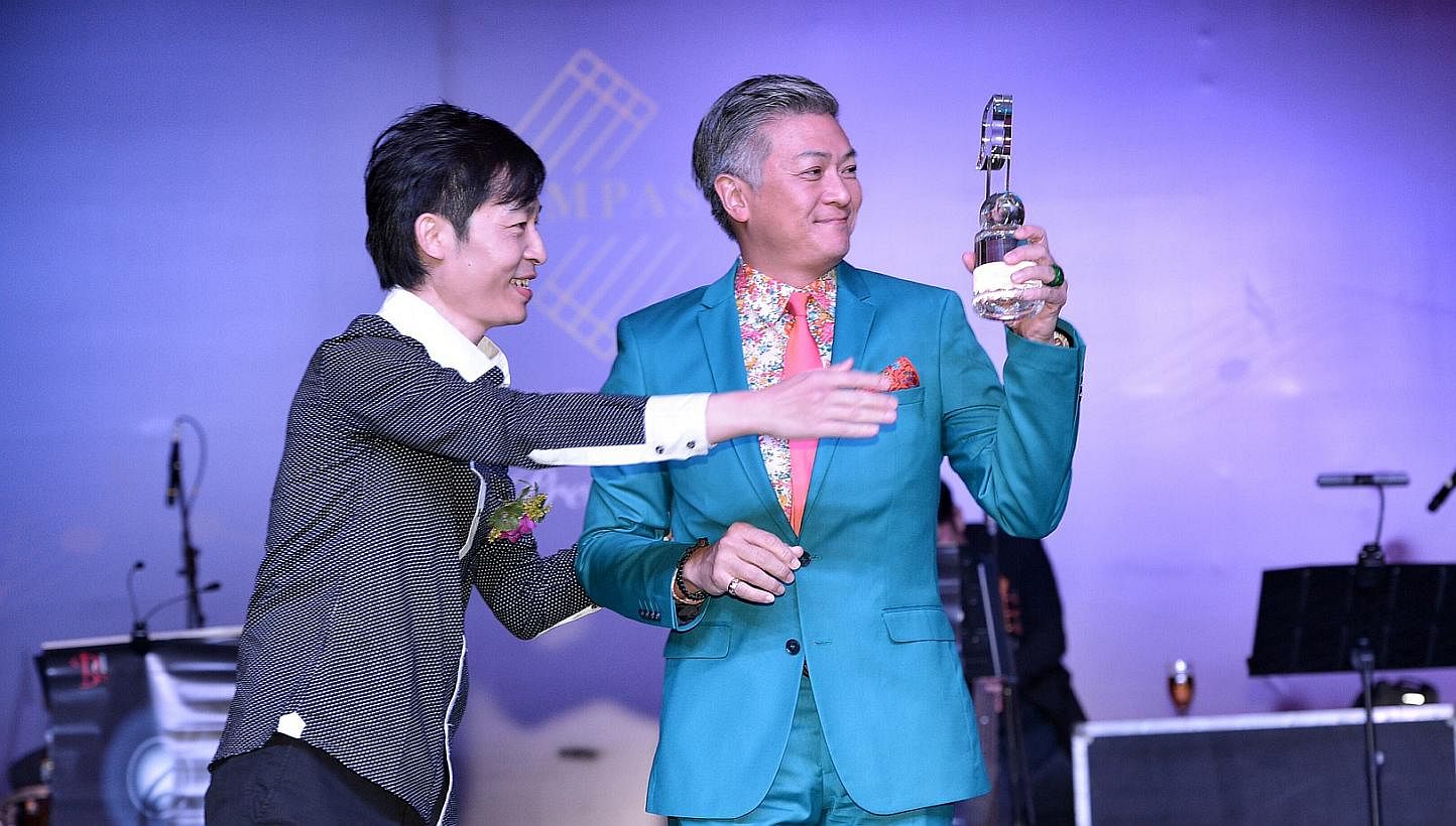 Composer Dick Lee (right) receiving the award for top local English pop song from Compass director Liang Wern Fook last night.