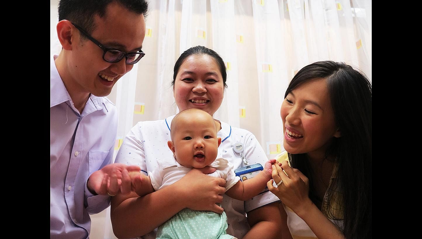Midwife Kelly Er (centre), who is with EMMa Care, helped Mr Wesley Lim and his wife Stephanie with the natural birth of their daughter Agnes.