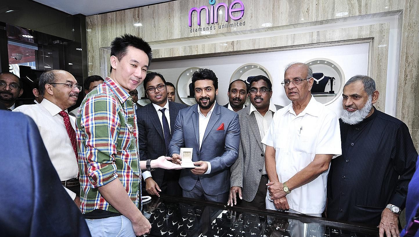 Indian actor Suriya handing over an item to a customer on the opening day of Malabar Gold & Diamonds' store in Syed Alwi Road. Malabar has its sights set on being the world's No. 1 jewellery retailer by 2015.