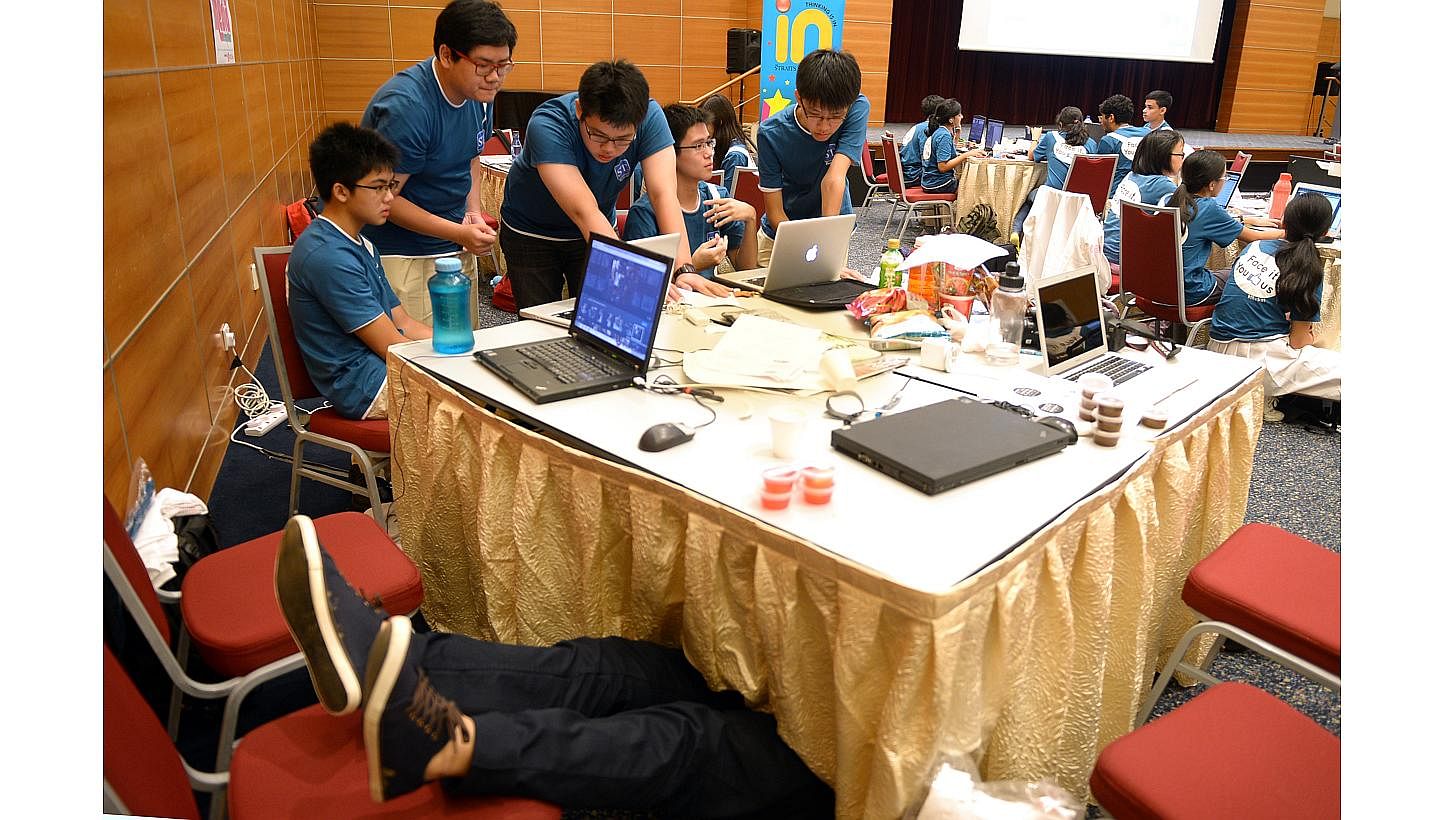 (From left) Hwa Chong Institution students Ian Wong (legs showing), Danyon Low, Denis Lan, Gaw Ban Siang, Brandon Hoong and Joel Lim. Ian Wong dived under his team's workbench for a short nap during The Straits Times National Youth Media Competition,