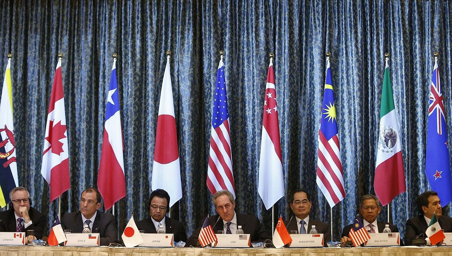 US Trade Representative Michael Froman (centre) speaks next to Japan's Economics Minister Akira Amari (centre left) and Singapore's Trade Minister Lim Hng Kiang (centre right), amongst trade ministers representing Canada, Peru, Malaysia and Mexico du