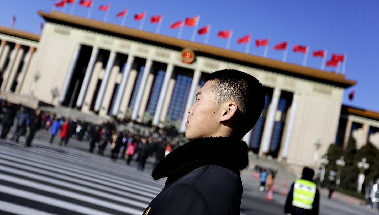 A soldier in plain clothes from the Chinese People's Liberation Army (PLA) stands guard in front of the Great Hall of the People, the venue of the annual session of China's parliament, the National People's Congress (NPC), in Beijing March 4, 2014. C