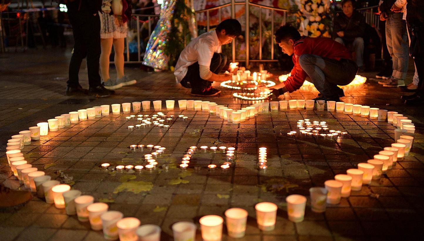 This picture taken on March 2, 2014 shows Chinese mourners lighting candles at the scene of the terror attack at the main train station in Kunming, south-west China's Yunnan province. Residents in several major cities across China have been unnerved 