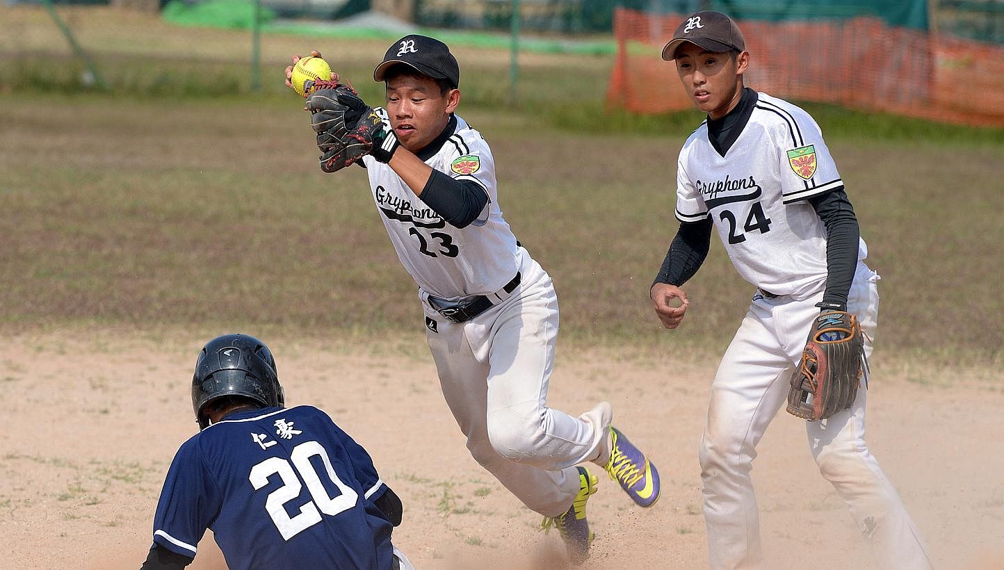 Raffles Institution's B Division boys' softball team (in white) retained their title after a thrilling battle against Catholic High School, winning 9-8 at the Kallang Field yesterday afternoon. -- ST PHOTO:&nbsp;LIM SIN THAI
