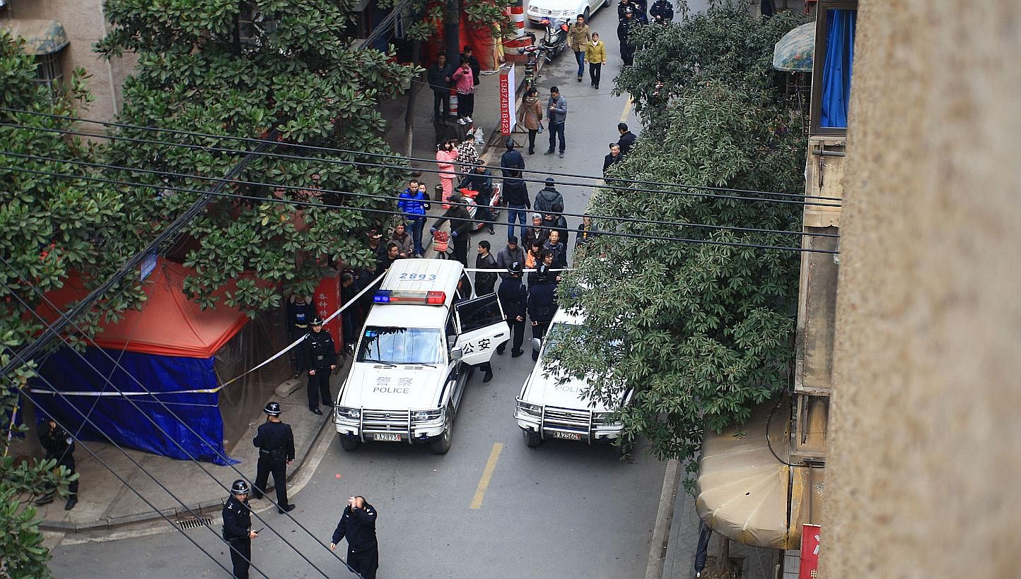 Police inspect the crime scene where attackers armed with knives killed at least one in Changsha, central China's Hunan province, on March 14, 2014.&nbsp;Barely two weeks after a brutal knife attack left dozens dead in south-western Kunming city, ano