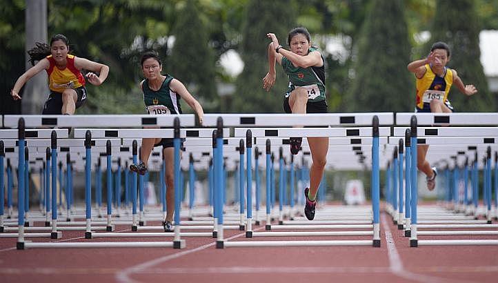 Jannah Wong (second from right) of Raffles Institution in action during the A-Girls 100 Metres Hurdles at the Schools' National Track and Field Championships on 8 April, 2014. Trailing her are (from left) Janine Foo of Hwa Chong Institution, Laura Ta