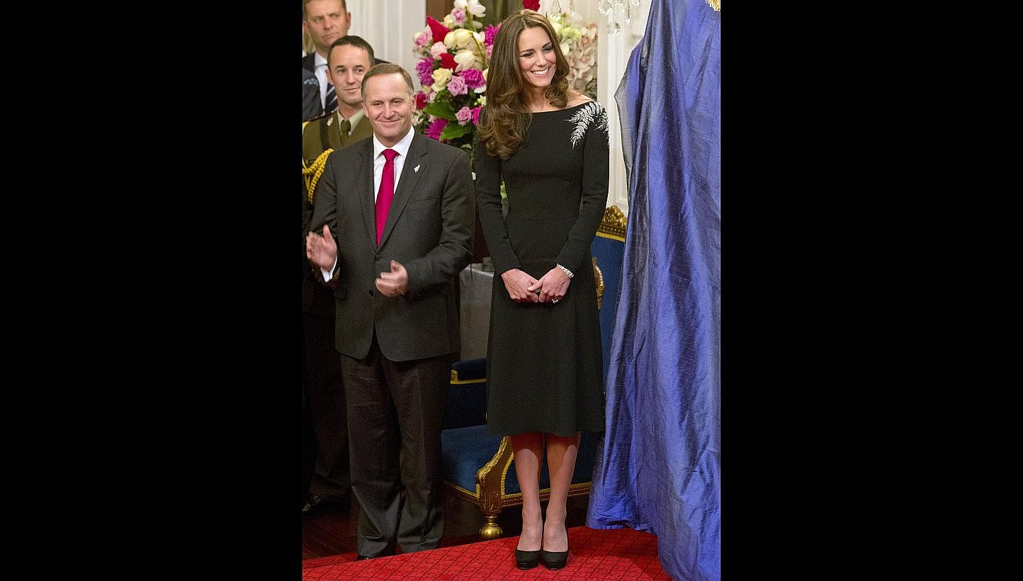 Catherine, the Duchess of Cambridge, with New Zealand Prime Minister John Key during the unveiling of a portrait of Queen Elizabeth II by New Zealand artist Nick Cuthell during a state reception at Government House in Wellington on April 10, 2014. --
