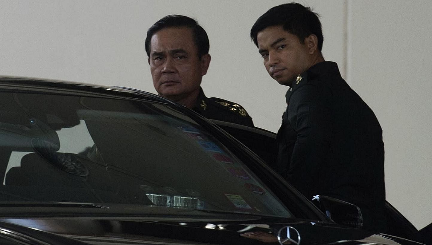 Thailand's army chief Prayut Chan-O-Cha (left) leaves after meeting with anti-government and pro-government leaders at the Army Club in Bangkok on May 22, 2014. -- PHOTO: AFP
