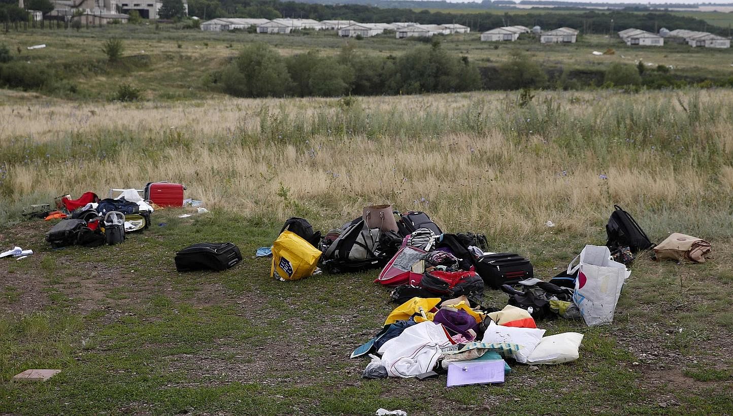 Luggage and belongings are seen near the site of Thursday's Malaysia Airlines Boeing 777 plane crash, near the settlement of Grabovo in the Donetsk region on July 18, 2014.&nbsp;-- PHOTO: REUTERS