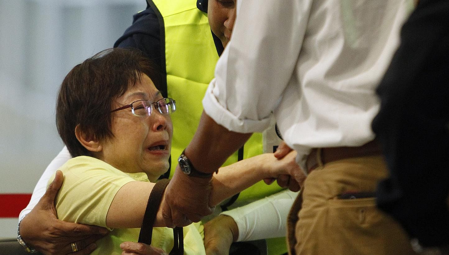 Malaysian Siti Dina weeps after seeing her daughter's name on the list of passengers on board Malaysia Airlines MH17 at the Kuala Lumpur International Airport in Sepang on July 18, 2014. -- PHOTO: REUTERS