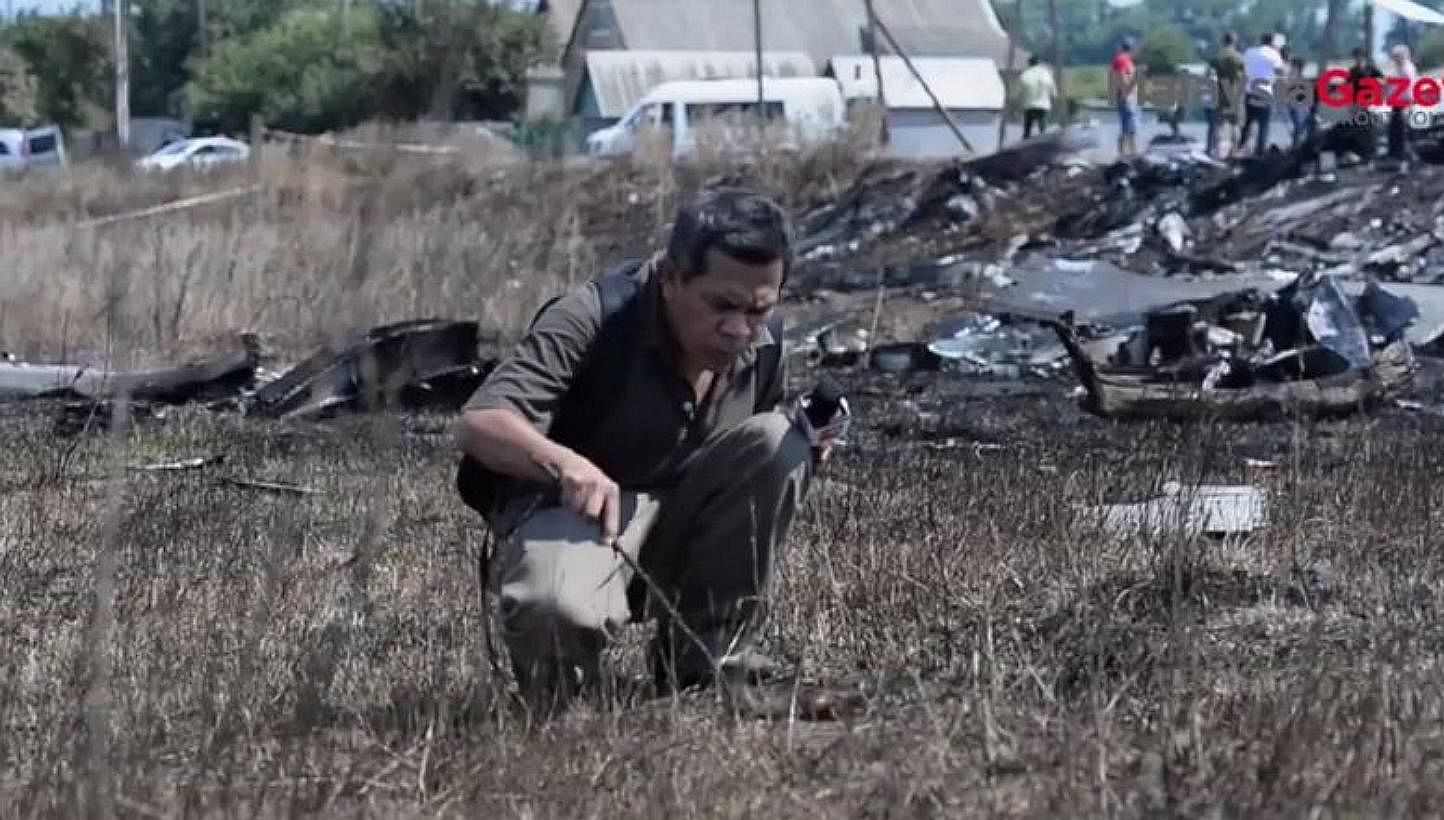 As Malaysia bemoans the lives lost when a missile hit Flight MH17 above eastern Ukraine this month, a Malaysian reporter did the unthinkable: Poking a burnt object believed to be human skin at the crash site for the camera.&nbsp;-- PHOTO: MALAYSIA GA