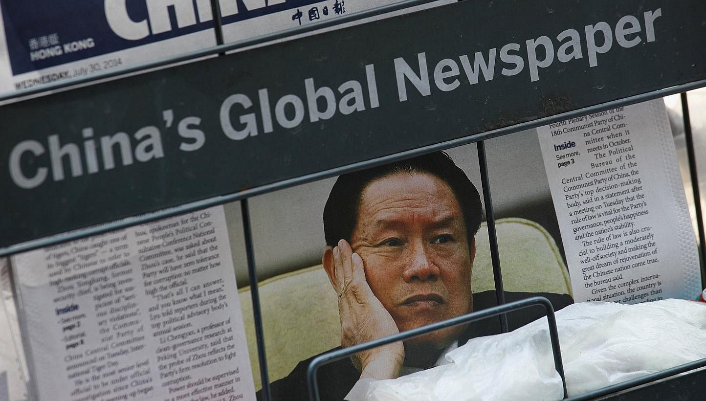 Former security czar Zhou Yongkang on the front page of the China Daily at a news-stand in Hong Kong yesterday. His expulsion from the CCP seems imminent and the likelihood of an open criminal trial is high, say experts.