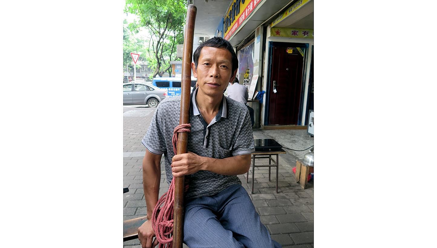Deep lines edge the tanned face of Mr Shu Xiaoping, a hint of the life as a farmer he left behind when he moved from a rural village to the city centre of Chongqing more than a decade ago. A cigarette in hand and a sturdy bamboo pole in the other, th