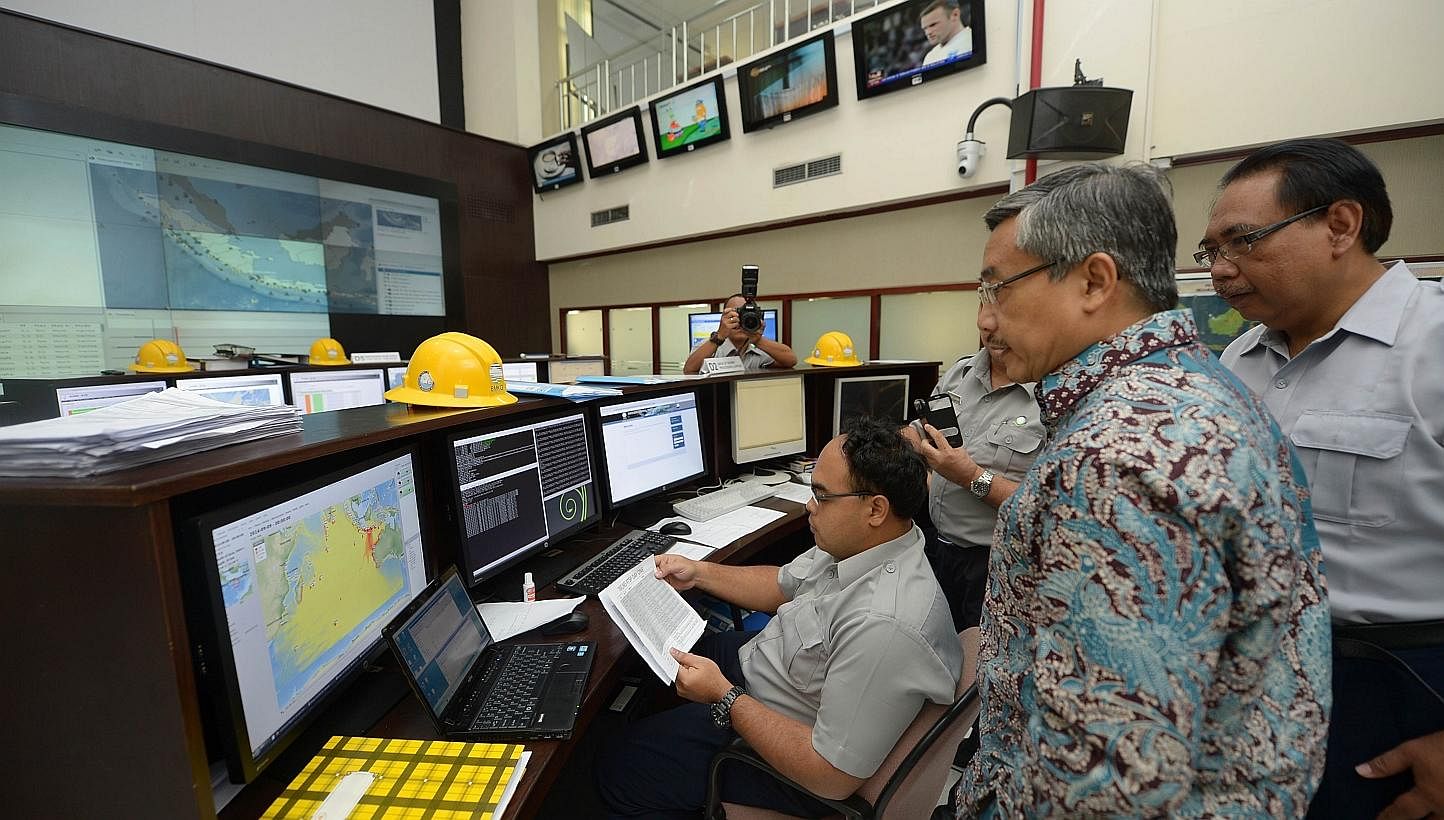 Andi Eka Sakya (2nd right), head of Indonesia's Agency for Meteorological, Climatological and Geophysics (BMKG), and Mochammad Riyadi (back right), director for the Earthquake and Tsunami Center in Jakarta, examine the Indian Ocean-wide tsunami exerc