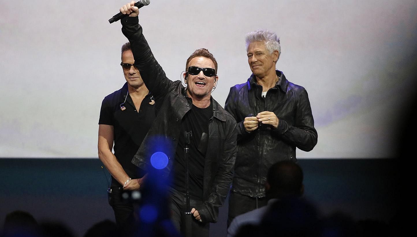 Bono (centre) of U2 after a performance at an Apple event in California recently. -- PHOTO: REUTERS