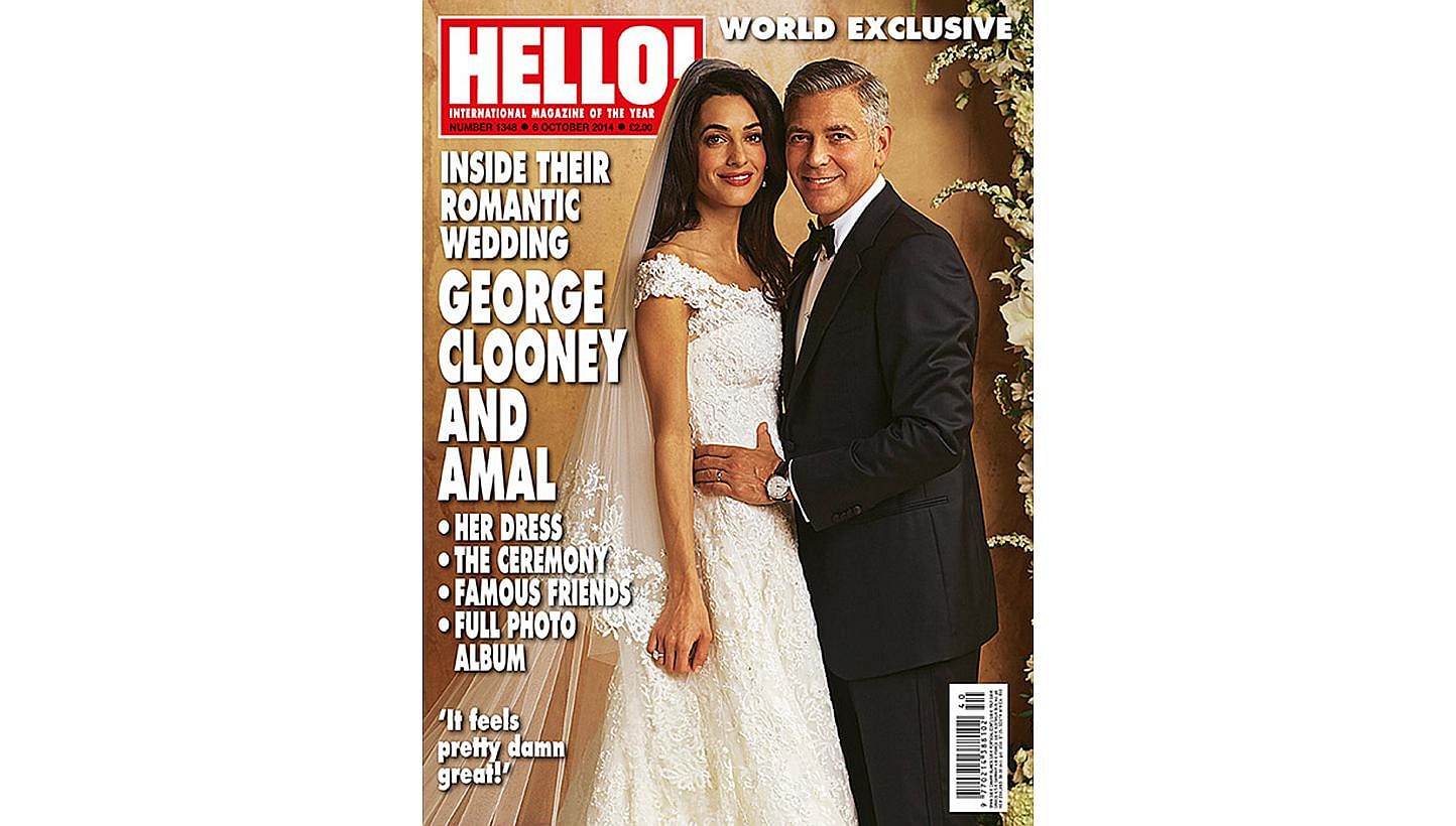 Human rights lawyer Amal Alamuddin, wearing her wedding dress, and her husband, actor George Clooney. -- PHOTO: HELLOMAGAZINE.COM