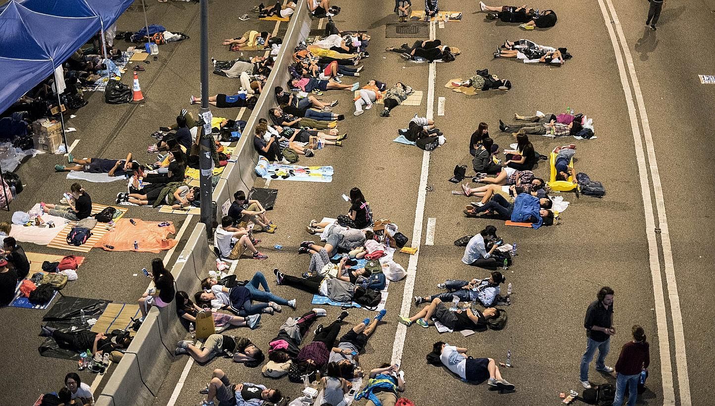 Pro-democracy protesters rest on a highway next to the central government offices in Hong Kong on Oct 6, 2014. -- PHOTO: AFP
