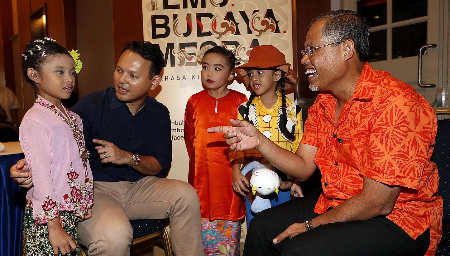 Mr Zaqy Mohamad, (second, left), chairman of the organising committee of Malay Language month and Mr Masagos Zulkifli, (right), chairman of the Malay Language Council, interacting with Putri Emily Muhammad Joehadi,7, (in light purple), Seri Emaryana 