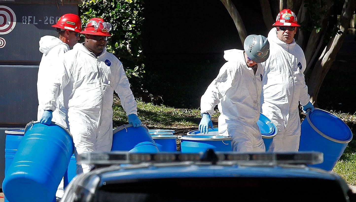 Hazmat workers with Protect Environmental unload barrels in preparation for decontaminating an apartment at The Village Bend East apartment complex where a second health-care worker who has tested positive for the Ebola virus resides on Oct 15, 2014 