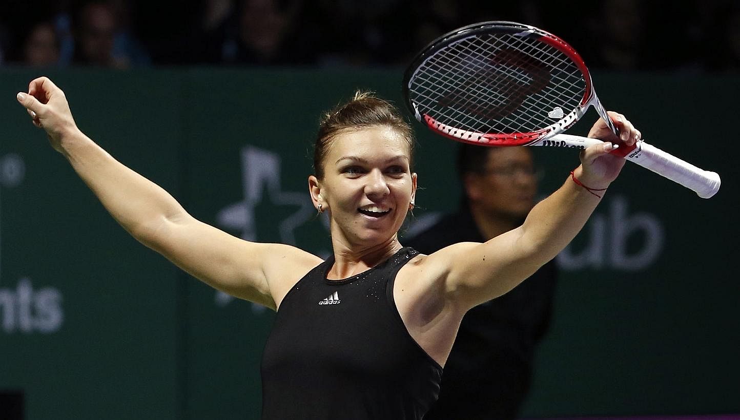Simona Halep of Romania celebrates her win over Serena Williams of the US during their WTA Finals singles tennis match at the Singapore Indoor Stadium on Oct 22, 2014. -- PHOTO: REUTERS