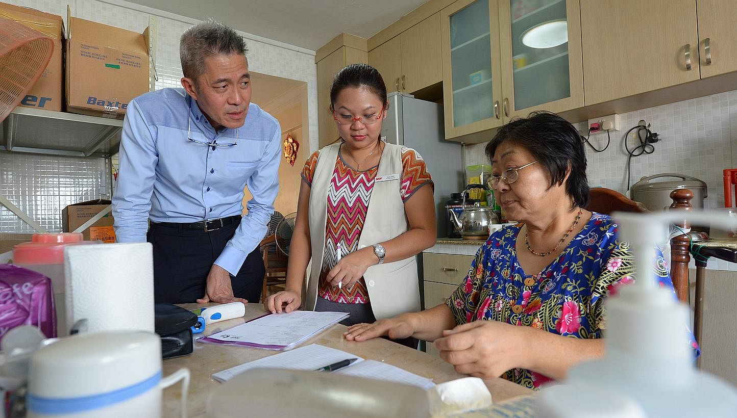 National Kidney Foundation chief executive Edmund Kwok and nurse Tracy Teo at the home of dialysis patient Yeo Thiam Keow, 61, a housewife. Mr Kwok regularly accompanies nurses and logistics staff when they visit patients' homes. Every week, he visit