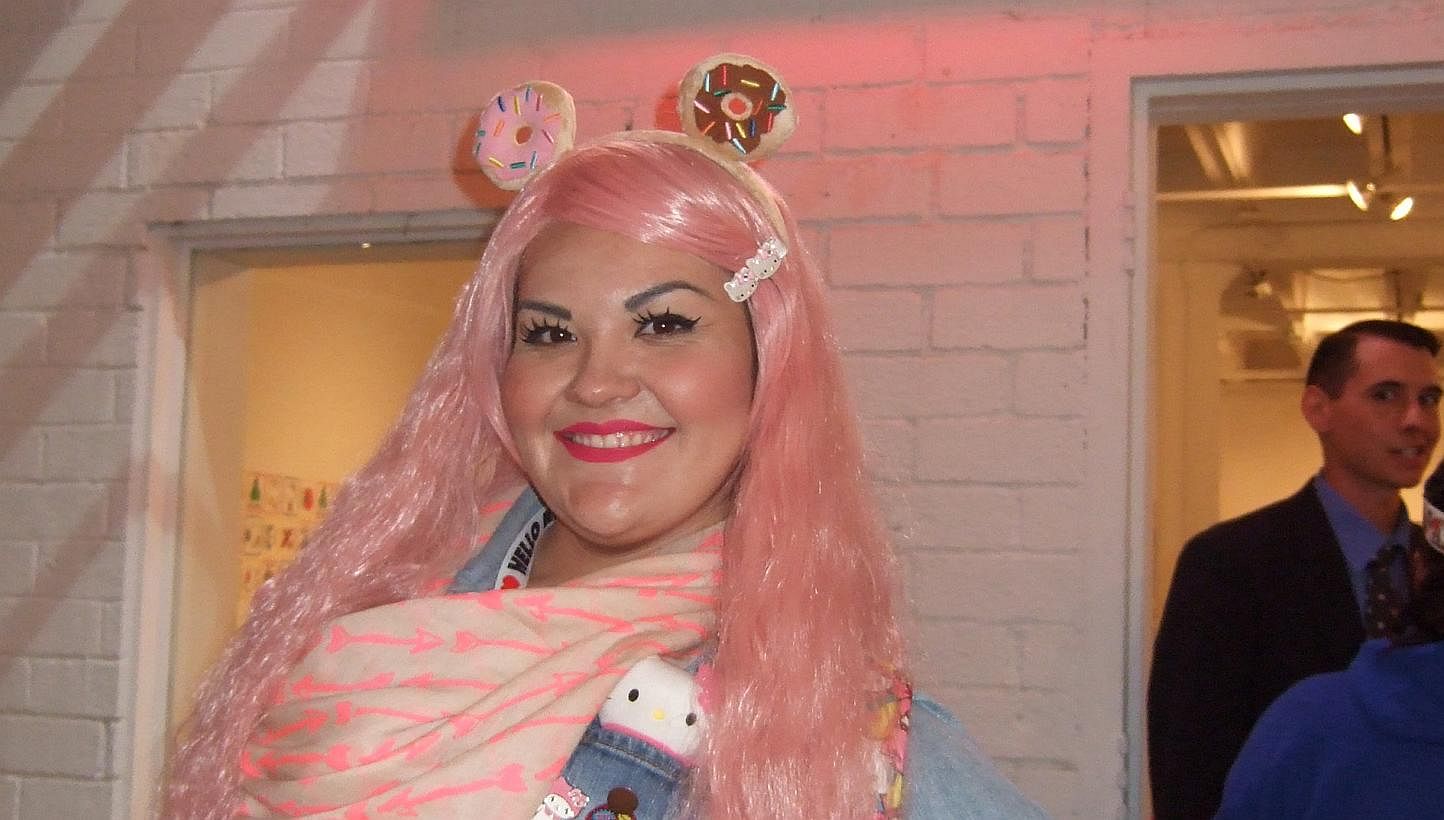 Gina Becerra, 32, a legal process-serving specialist, in full cosplay get-up and wearing her Hello Kitty charm bracelet as she waits to get her free Hello Kitty tattoo: “As a little girl I used to save my pennies just to go by an eraser or a stick 
