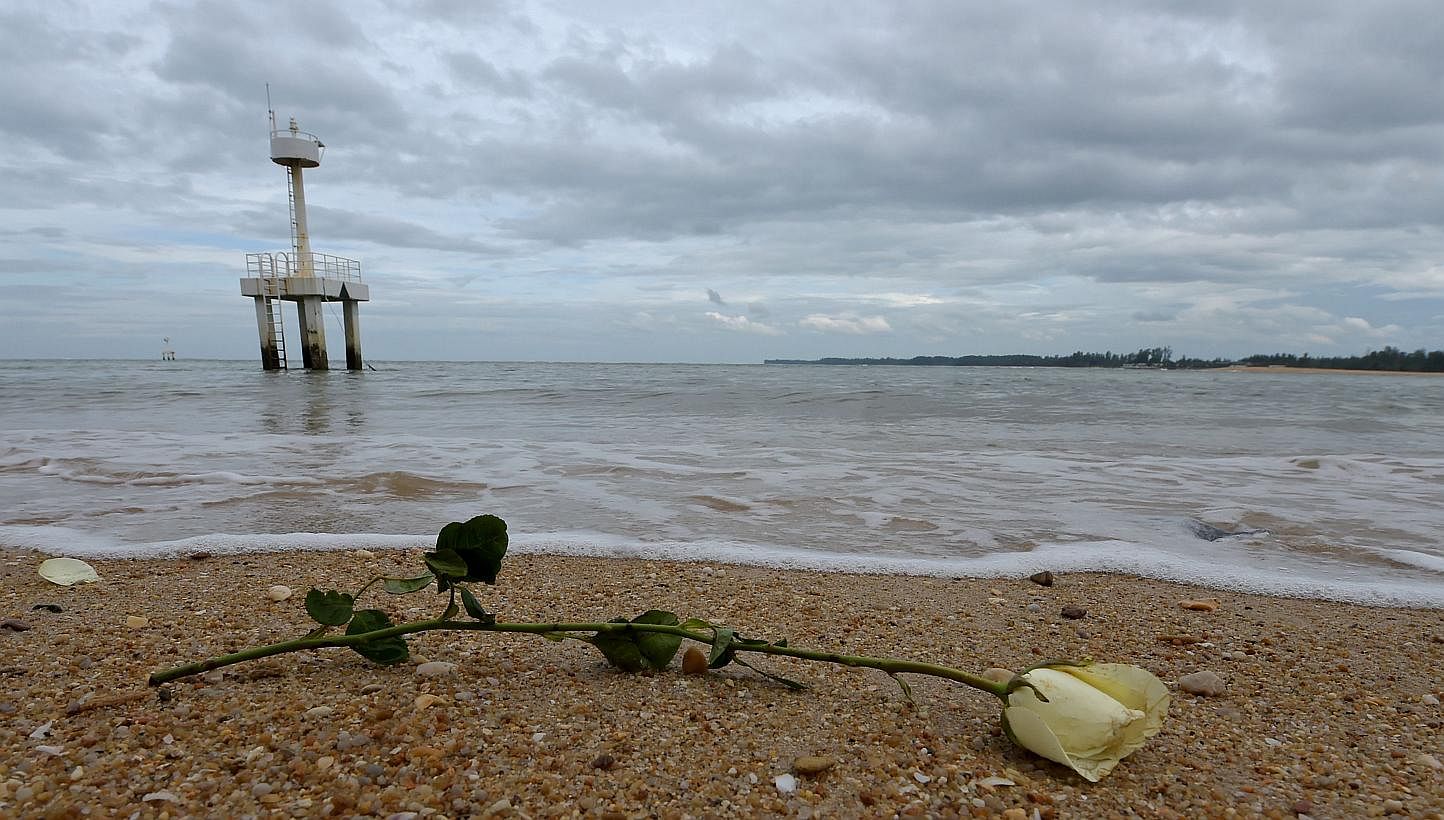 A rose sits on the beach near the Ban Nam Khem tsunami memorial park wall as the tenth anniversary of the 2004 tsunami is remembered in Phang-nga province on Dec 26, 2014. -- PHOTO: AFP