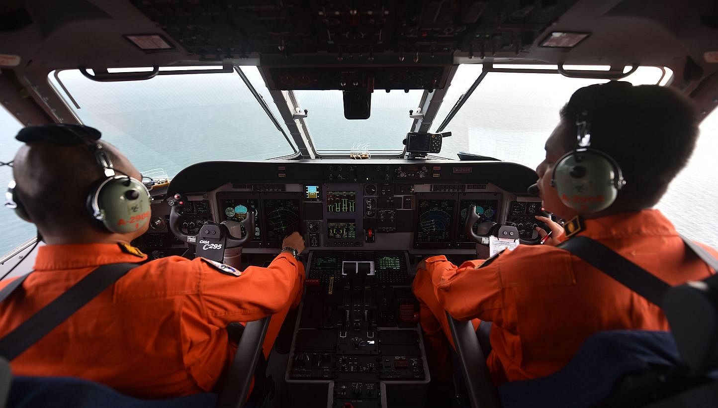 Pilots of the Indonesian air force keeping a look out during search operations for the missing AirAsia flight QZ8501, in Pangkalan Bun, Central Kalimantan on Dec 30, 2014. -- PHOTO: AFP