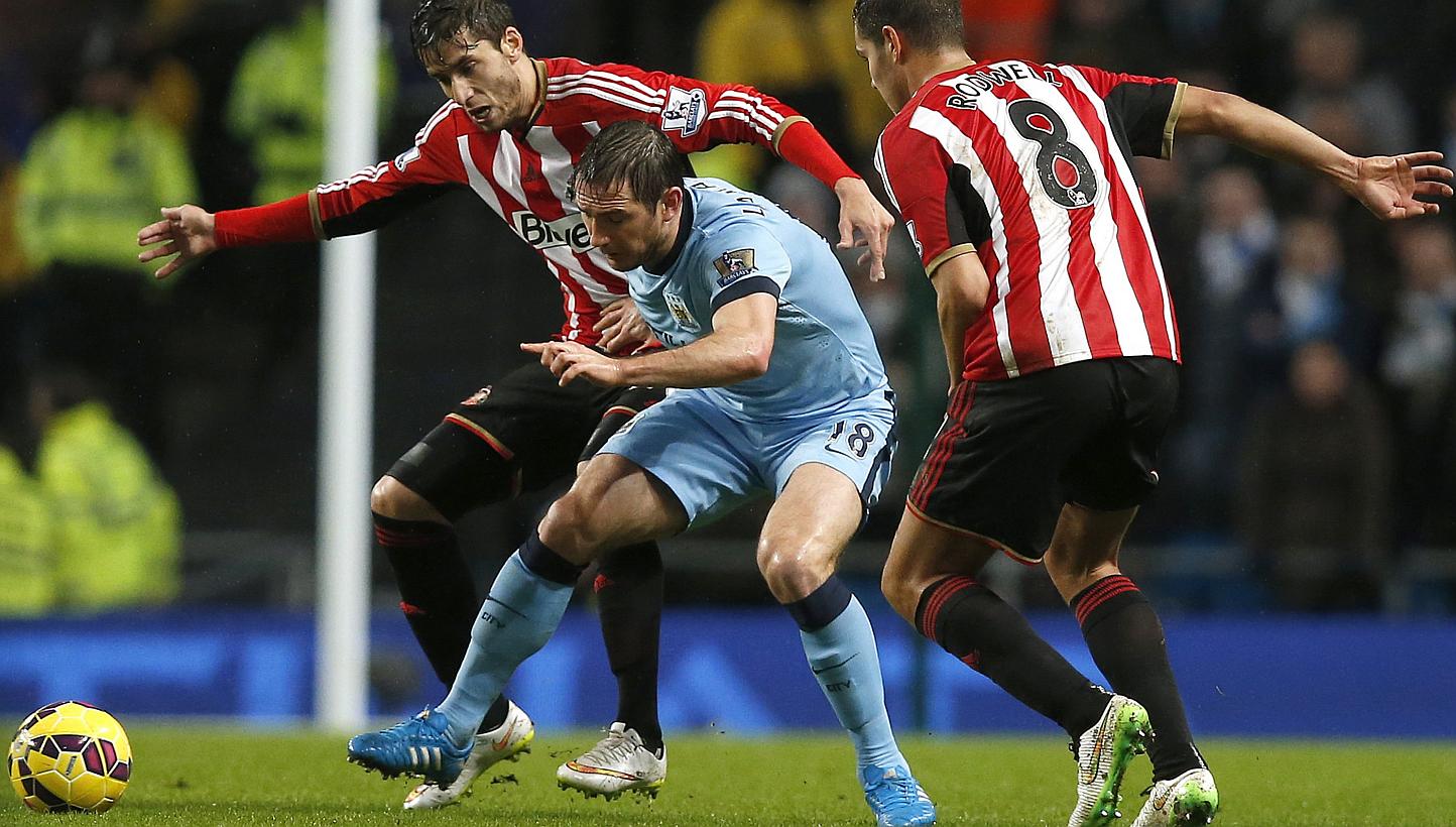Manchester City's Frank Lampard (centre) is challenged by Sunderland's Ricardo Alvarez (left) and Jack Rodwell during their English Premier League soccer match at the Etihad Stadium in Manchester, northern England Jan 1, 2015. -- PHOTO: REUTERS