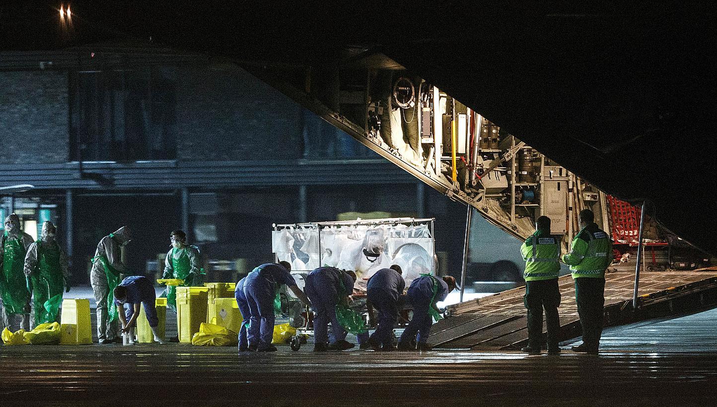 A British nurse&nbsp;who was diagnosed with Ebola after returning from Sierra Leone is wheeled in a quarantine tent trolley onto a Hercules Transport plane at Glasgow International Airport on Dec 30, 2014. -- PHOTO: AFP