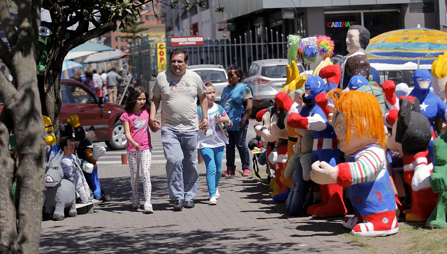 Pedestrians walking next to handmade puppets on a street in Quito, Ecuador, Dec 30, 2014. Traditionally, at the end of the year, Ecuadorians burn puppets to symbolise the end of the old and bad and the starting of the good and new. Ecuador was named 