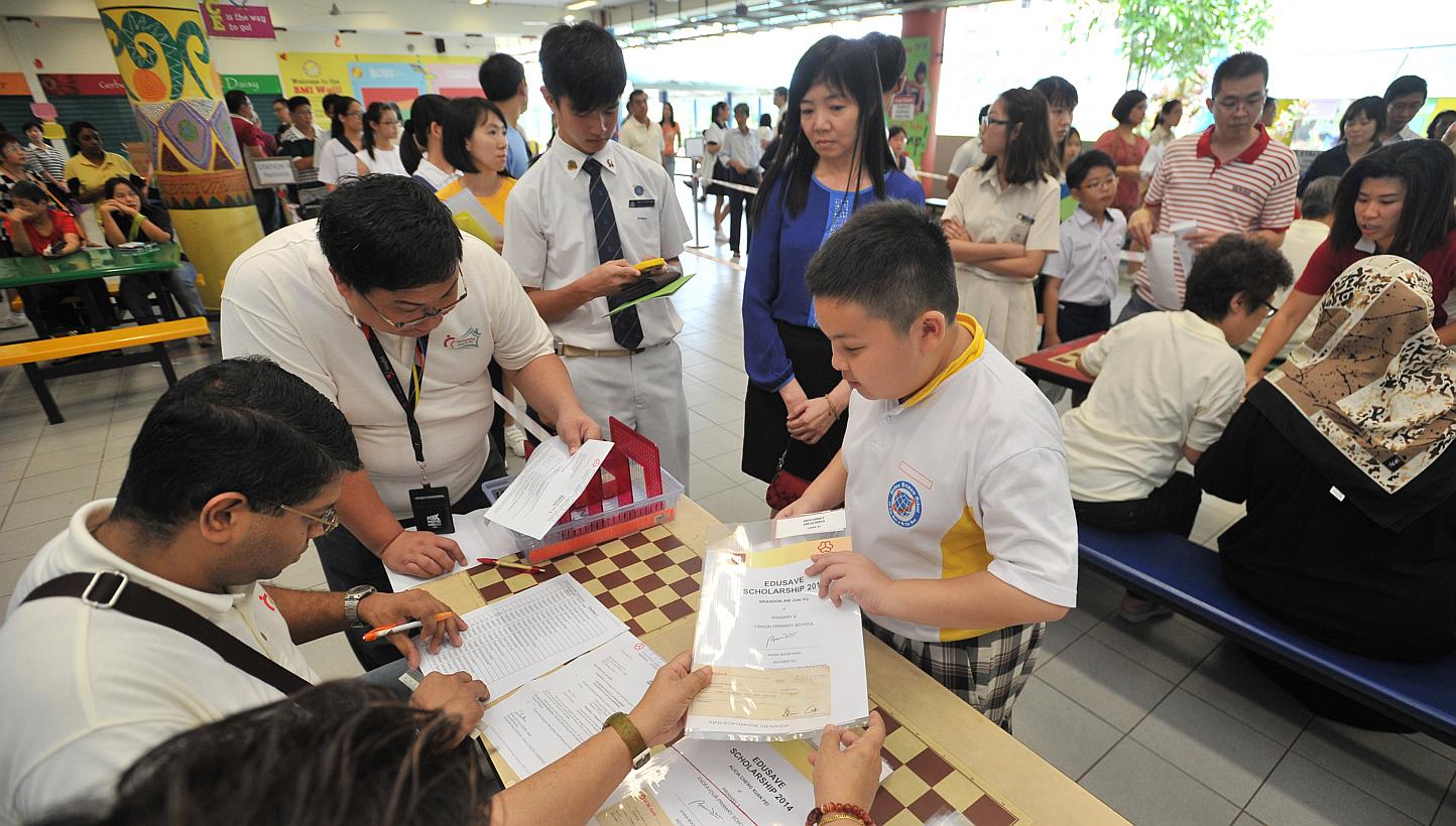 Students collecting their edusave awards at the Sembawang Edusave Awards Presentation Ceremony at Wellington Primary School on Jan 3, 2015. -- ST PHOTO: LIM YAOHUI FOR THE STRAITS TIMES
