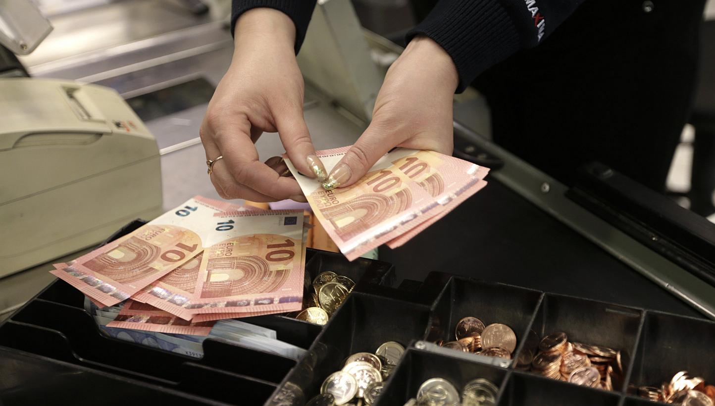 A cashier counts euro banknotes in a shop in Vilnius, Lithuania. The single currency tumbled to its lowest since early 2006 in Asia on Monday as a wave of stop-loss sales were tripped on the break of major chart support, sending the U.S. dollar flyin