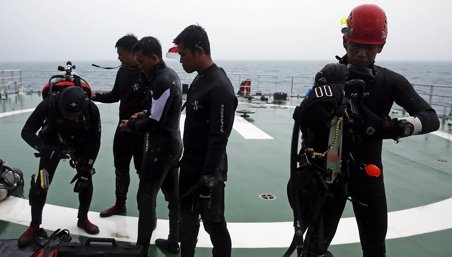 A group of divers preparing their gear on the deck of the ship KN Purworejo during a search operation for passengers onboard AirAsia Flight QZ8501 in the Java Sea on Jan 4, 2015. -- PHOTO: REUTERS