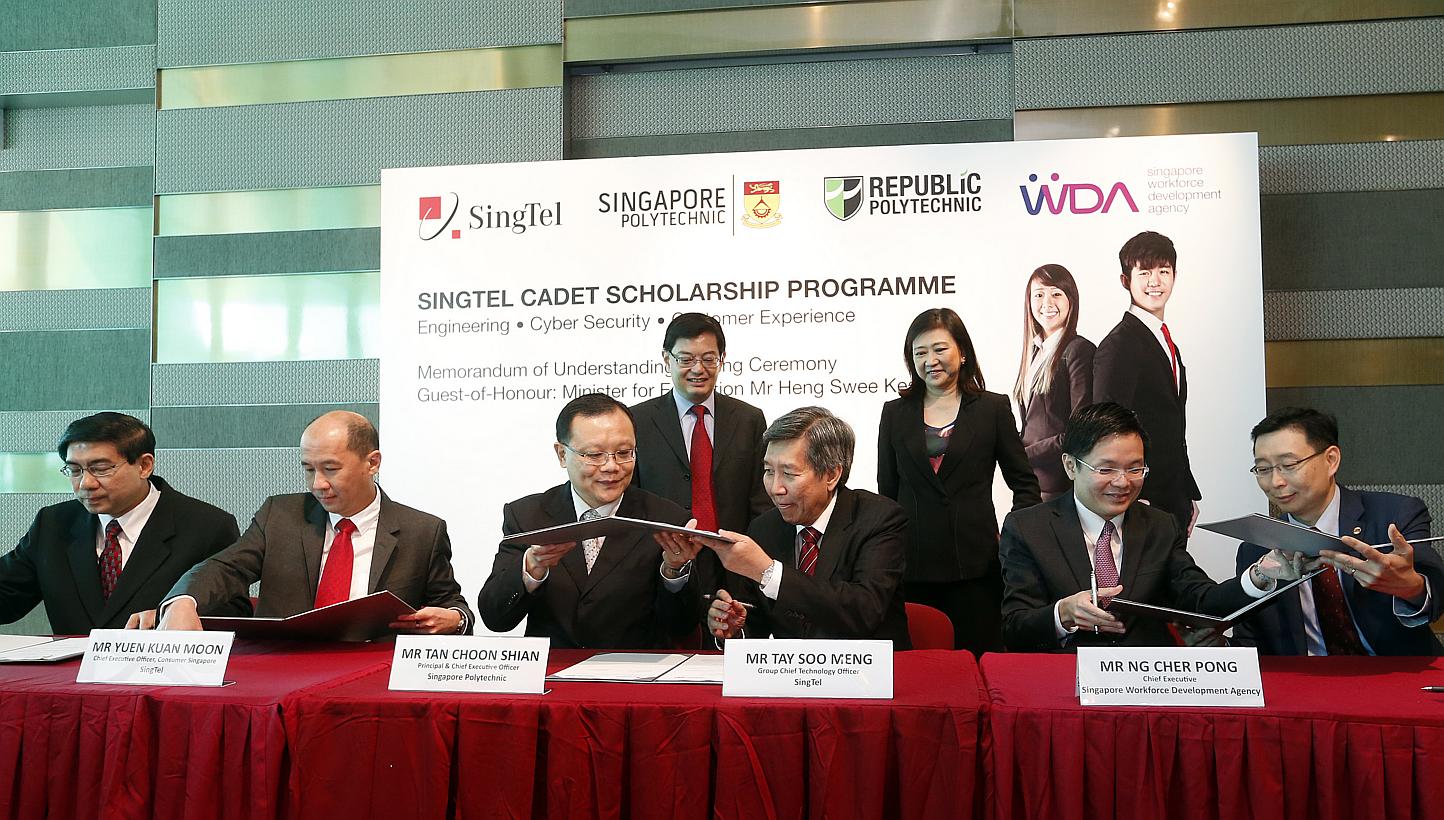 Minister for Education Heng Swee Keat (back row, left) witnesses the signing of an MOU for a new diploma scholarship programme launched by telco SingTel on Tuesday, and jointly developed with Singapore and Republic polytechnics. -- ST PHOTO: CH