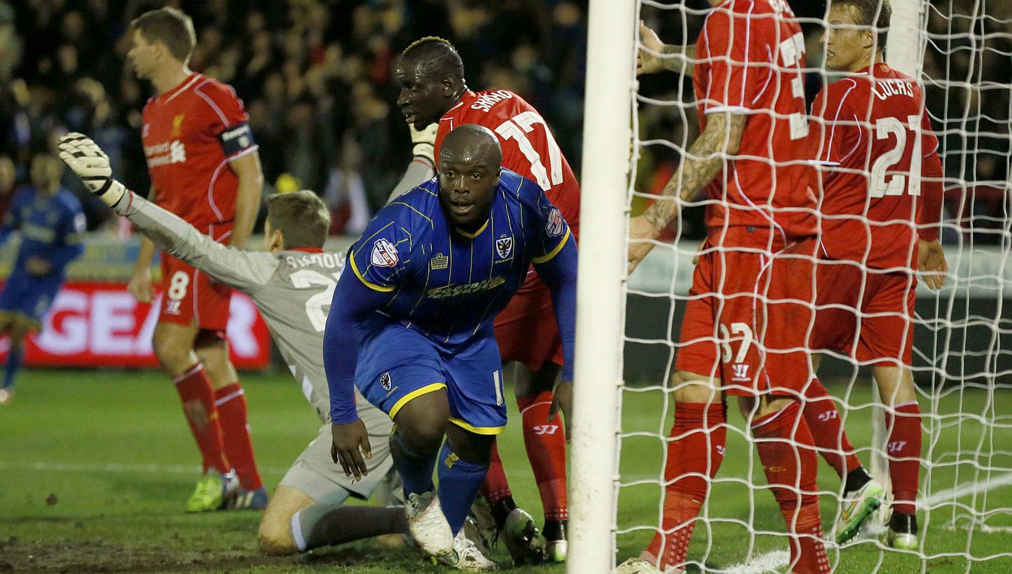 AFC Wimbledon's Adebayo Akinfenwa (centre) celebrates after scoring during the FA Cup third round soccer match against Liverpool at Kingsmeadow Stadium in Kingston-upon-Thames, southern England on Jan 5, 2015. -- PHOTO: REUTERS