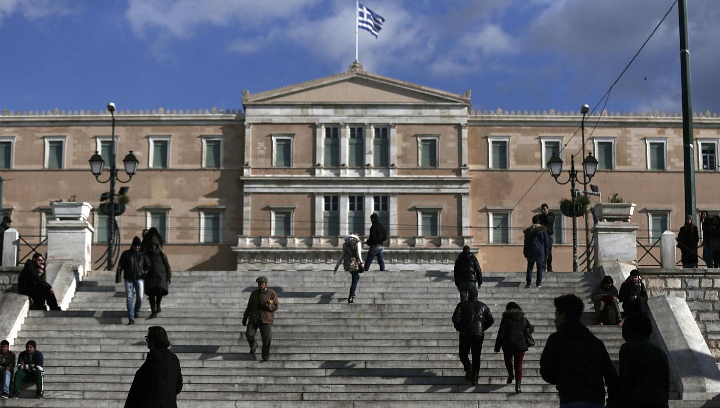 People making their way in central Syntagma Square with the parliament building in the background in Athens on Jan 6, 2015. Germany and France are taking a coordinated and calculated risk in the hope of averting a leftist victory in Greece's general