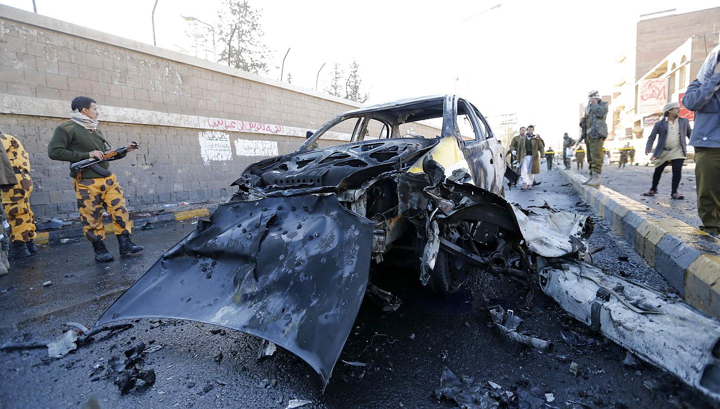 Police officers look at the wreckage of a car at the scene of a car bomb outside the police college in Sanaa Jan 7, 2015.&nbsp;&nbsp;A car bomb tore through dozens of Yemenis lined up at a police academy in Sanaa on Wednesday, killing 37 in the lates
