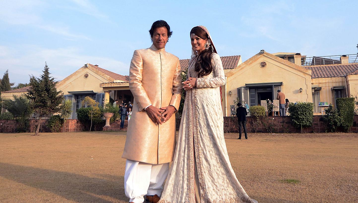 In this handout photograph released by the Pakistan Tehreek Insaf (PTI) party on Jan 8, 2015, Pakistani opposition leader Imran Khan (left) and new wife Reham Khan pose for a photograph during their wedding ceremony at his house in Islamabad. -- PHOT