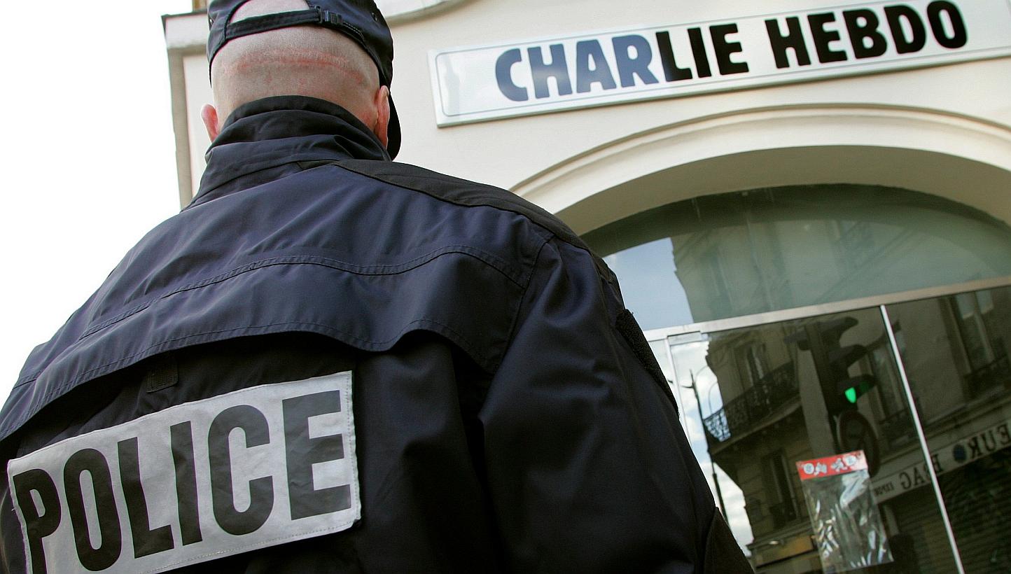 A policeman stands guard outside the French satirical weekly "Charlie Hebdo" in Paris on Feb 9, 2006. -- PHOTO: REUTERS