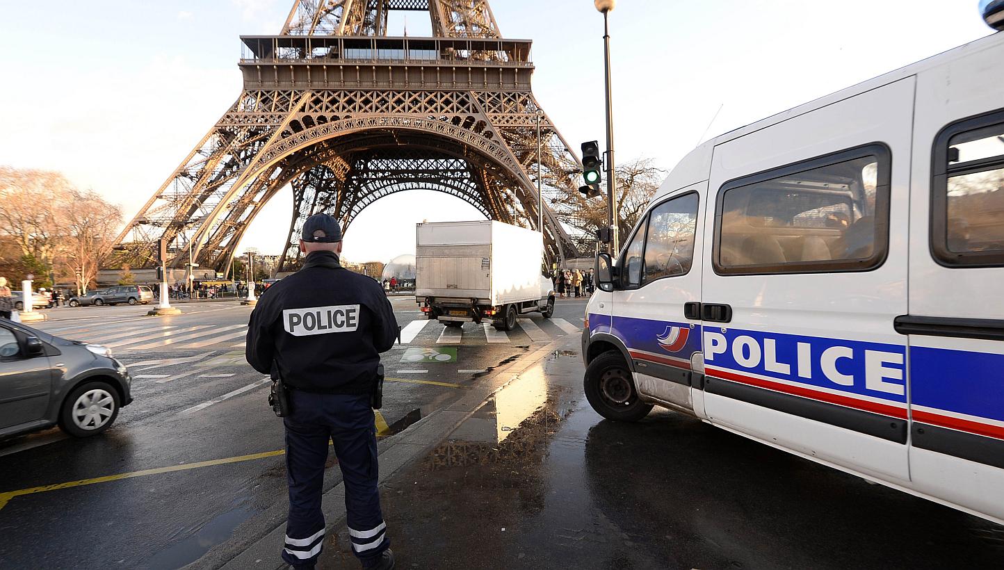 A French police officer stands in front of the Eiffel Tower on Jan 8, 2015 in Paris. Having known ties to jihadist groups is no guarantee a person will be under constant surveillance by the French authorities, experts say. -- PHOTO: AFP&nbsp;