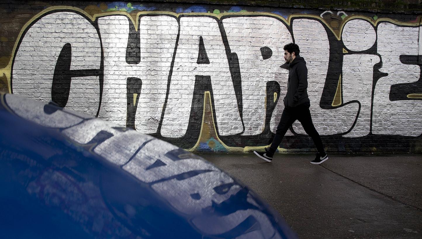 A pedestrian walks past graffiti that reads "[Je suis] Charlie" (I am Charlie), in east London on Jan 10, 2015.&nbsp;Hundreds in southern Afghanistan rallied to praise the killing of 12 people at the French newspaper Charlie Hebdo, calling the two gu