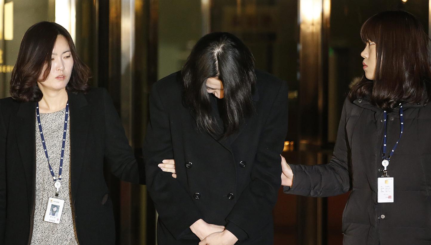 Heather Cho (centre), daughter of chairman of Korean Air Lines, Cho Yang Ho, leaves the Seoul Western District Prosecutor’s office for a detention facility after a Korean court ordered her to be detained on Dec 30, 2014. -- PHOTO: REUTERS