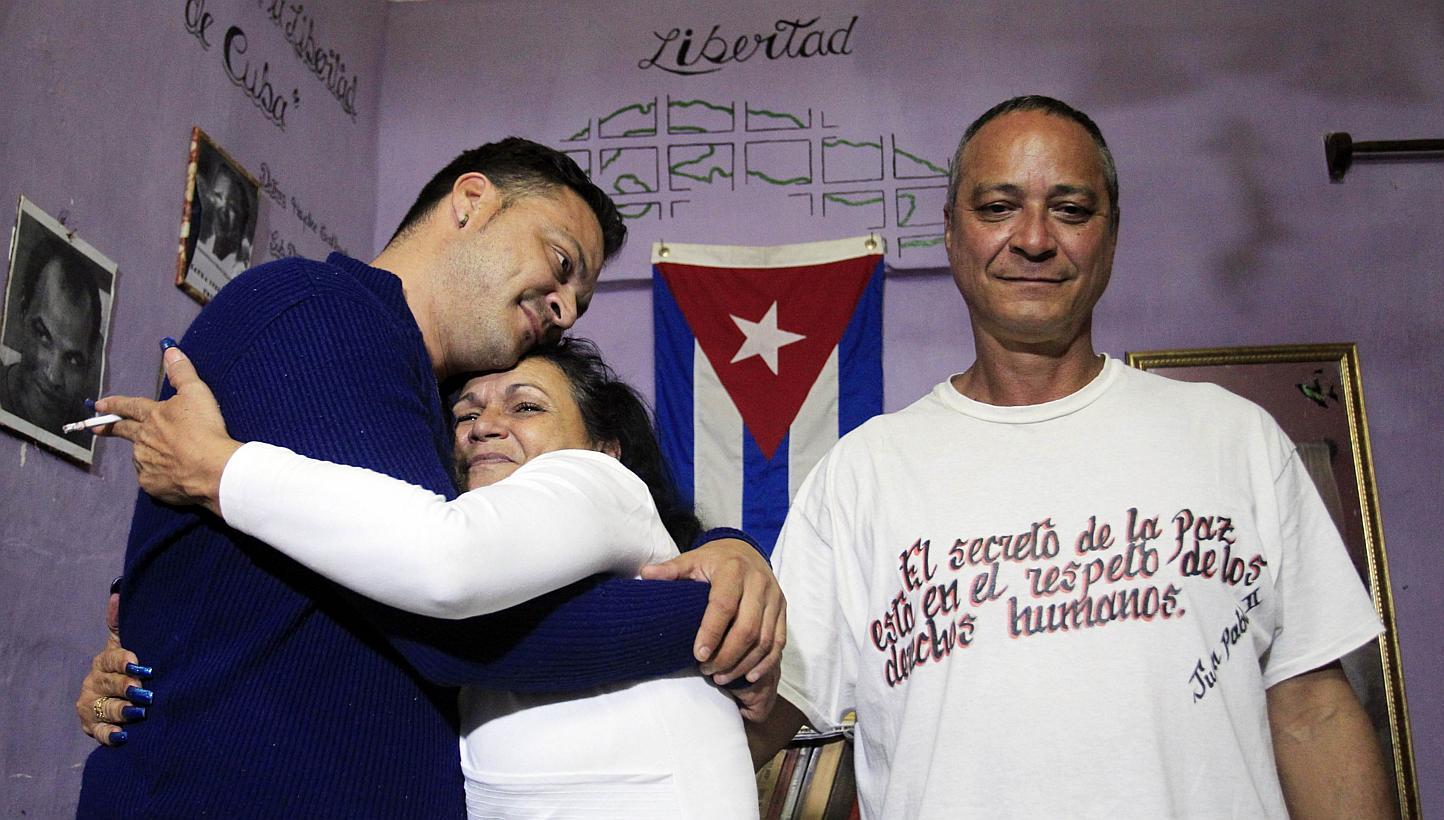 Angel Figueredo (right) stands next to his wife Haydee Gallardo who hugs their son Reynier at their home in Havana, on Jan 8, 2015. Cuba has released all 53 political prisoners it agreed to free as part of a historic deal with the United States annou