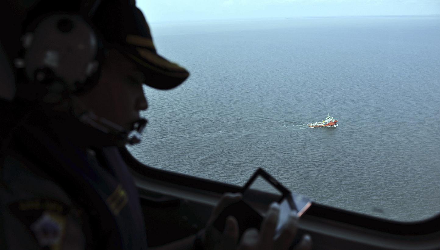 An Indonesian policeman watches from the air as the search operation in the Java sea goes underway. Indonesia's search and rescue agency said on Monday morning that search teams had managed to get part of the flight data recorder of the Indonesia Air
