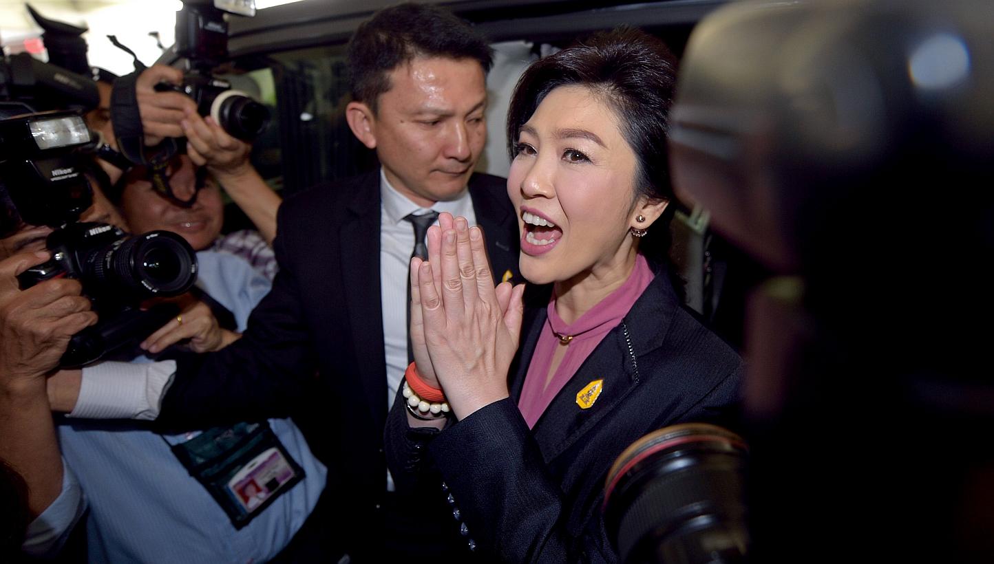 Ousted Thai prime minister Yingluck Shinawatra (centre) gestures a traditional greeting to members of the media in Bangkok on Jan 9, 2015. The&nbsp;Former Thai Prime Minister failed to appear at her second impeachment hearing on Friday, sending minis