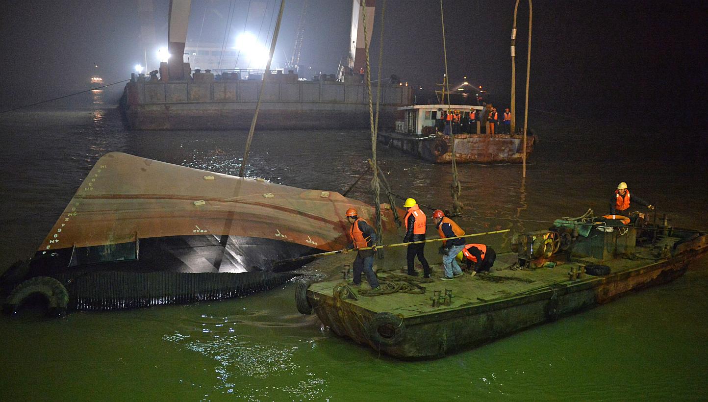 Salvage workers raising the tugboat on in the early hours of Jan 16, 2015. Twenty people, including Singaporeans and Japanese, are reported missing. -- PHOTO: XINHUA